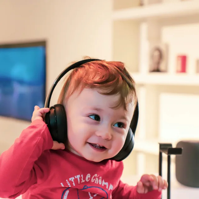 A small child in headphones, laughing